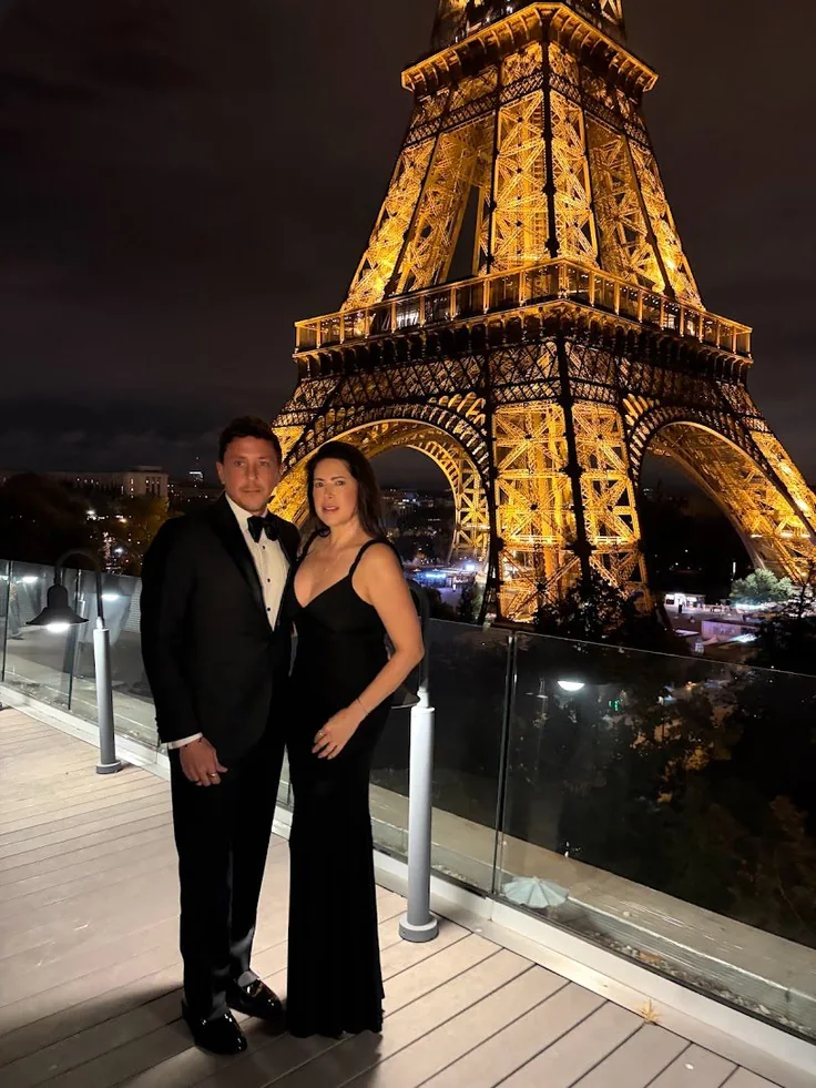 Michael and Gatinha dressed for an evening beneath the illuminated Eiffel Tower